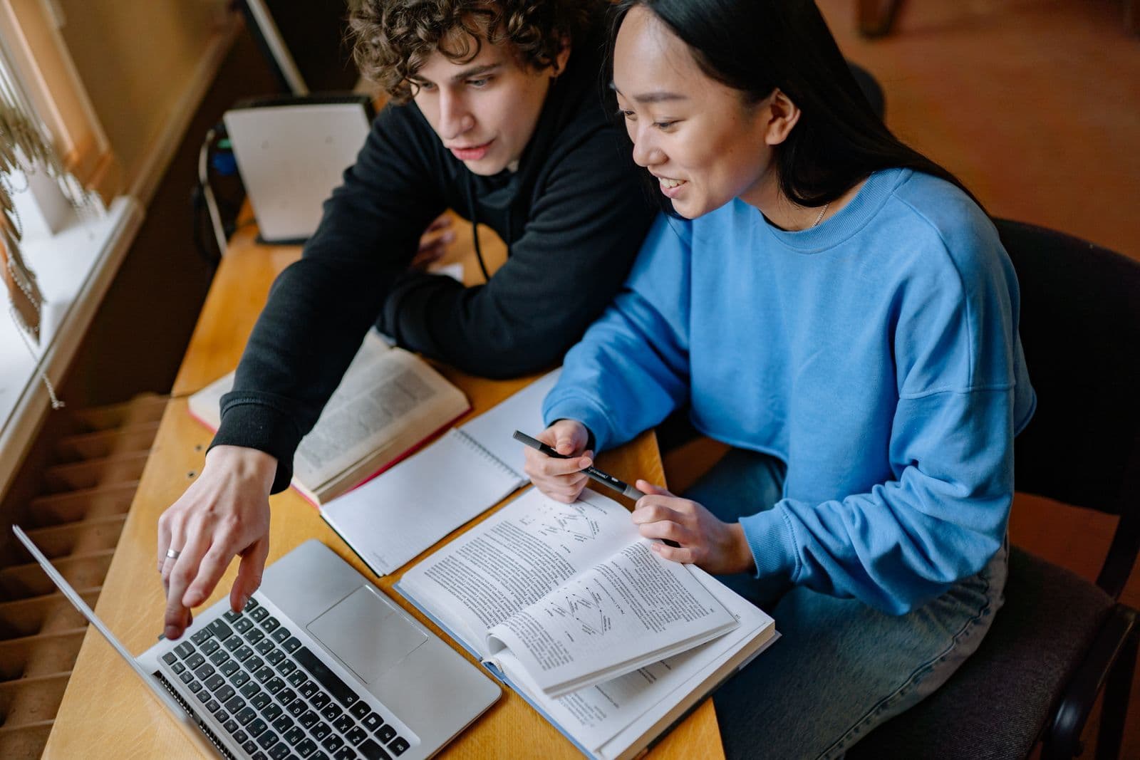 Two students working through code together on one laptop